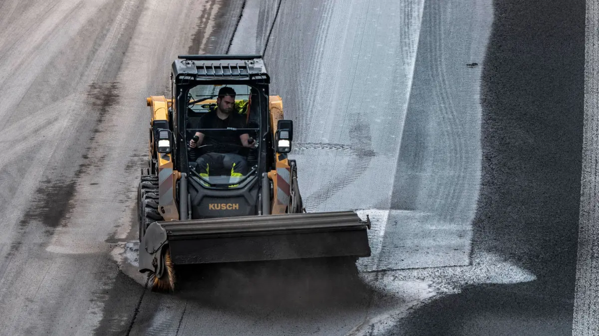 A52 Autobahnbaustelle: Sanierung der Autobahn A52 bei Essen, über 9 Jahre lange wird ein 8 KM langer Abschnitt zwischen der AS Essen-Kettwig und dem Autobahndreieck Essen-Ost grundsaniert, 6 Fahrspuren, Neubau der Entwässerungsleitungen, Fahrbahn, Brücken, Lärmschutzwänden, Verkehrseinrichtungen, hier letzter Abschnitt, Fahrtrichtung Düsseldorf, neuer Fahrbahnbelag, Verlegung von offenporigem Asphalt, hier das abtragen, fräsen, der alten Fahrbahn vor dem Aufbringen des neuen Flüsterasphalts, Kehrmaschine, Essen, NRW, Deutschland, A52 Autobahnbaustelle *** Reconstruction of the A52 highway near Essen, an 8 km long section between the Essen Kettwig interchange and the Essen Ost interchange will be completely renovated over a period of 9 years, 6 lanes, new