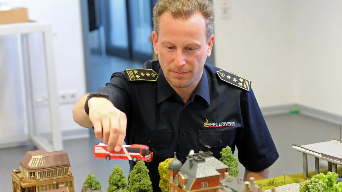 Reutlingens Feuerwehrkommandant Stefan Hermann bestückt die Planübungsplatte: Mit Modellbau-Elementen werden Einsatzszenarien nachgestellt.
