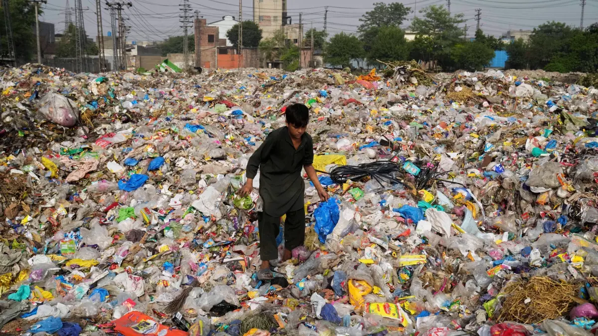 Plastikmüll in Pakistan: PRODUKTION - 07.08.2025, Pakistan, Lahore: Ein Müllsammler sammelt wiederverwertbare Gegenstände, darunter Plastik, auf einer Mülldeponie. In Genf finden derzeit Verhandlungen über eine UN-Plastik-Konvention statt. Foto: K.M. Chaudary/AP/dpa +++ dpa-Bildfunk +++