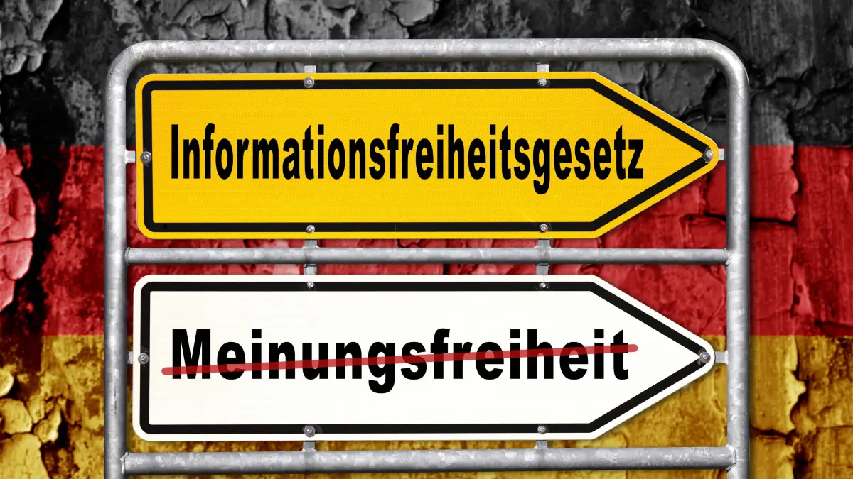 Bavaria, Germany - March 30, 2025: PHOTOMONTAGE, Two directional signs in front of a German flag: Freedom of Information: Bavaria, Germany - March 30, 2025: PHOTOMONTAGE, Two directional signs in front of a German flag: Freedom of Information Act at the top, freedom of expression crossed out with a red line at the bottom. Motif in connection with discussions about information rights and public communication. *** FOTOMONTAGE, Zwei Richtungsschilder vor einer Deutschlandflagge: Oben Informationsfreiheitsgesetz, unten Meinungsfreiheit mit rotem Strich durchgestrichen. Motiv im Zusammenhang mit Diskussionen über Informationsrechte und öffentliche Kommunikation.