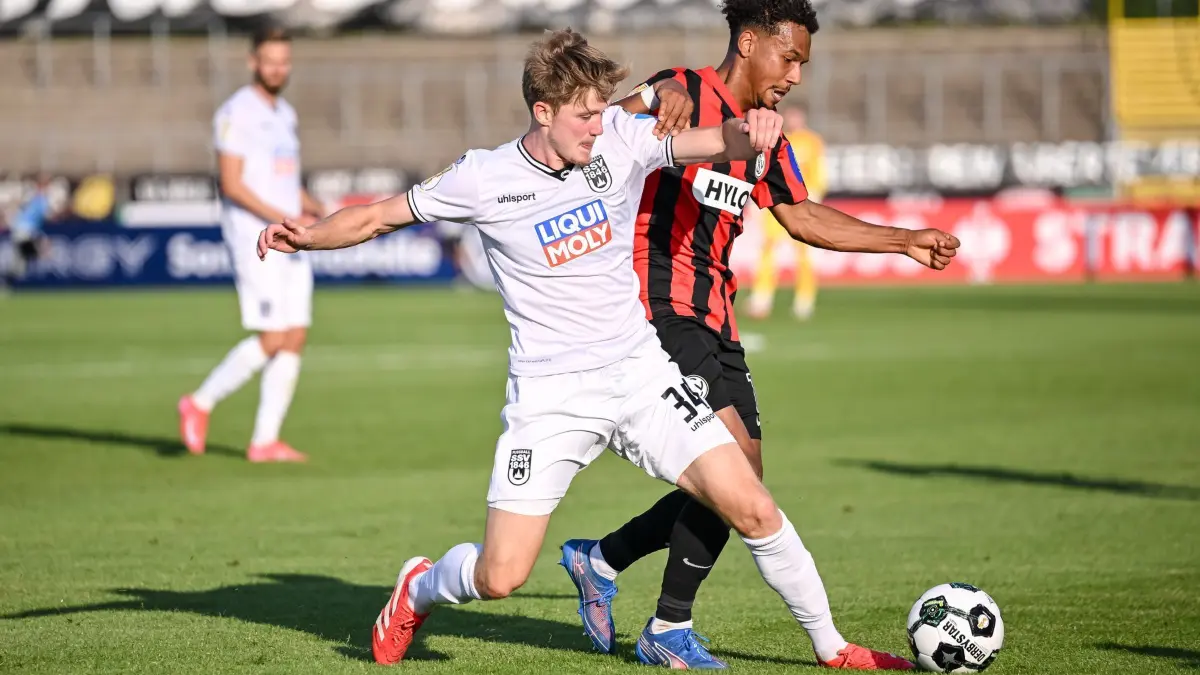 SSV Ulm 1846 - SV Elversberg: 17.08.2025, Baden-Württemberg, Ulm: Fußball: DFB-Pokal, SSV Ulm 1846 - SV Elversberg, 1. Runde, Donaustadion. Jan Boller (l, SSV Ulm 1846 Fußball) in Aktion gegen Bambasé Conté (SV 07 Elversberg). Foto: Harry Langer/dpa - WICHTIGER HINWEIS: Gemäß den Vorgaben der DFL Deutsche Fußball Liga bzw. des DFB Deutscher Fußball-Bund ist es untersagt, in dem Stadion und/oder vom Spiel angefertigte Fotoaufnahmen in Form von Sequenzbildern und/oder videoähnlichen Fotostrecken zu verwerten bzw. verwerten zu lassen. +++ dpa-Bildfunk +++