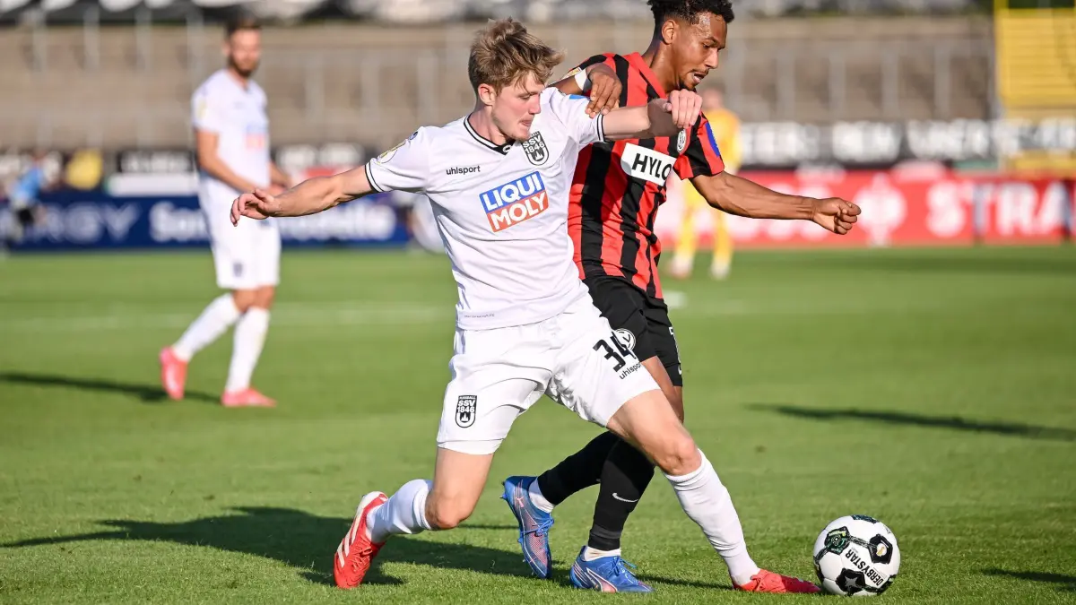 SSV Ulm 1846 - SV Elversberg: 17.08.2025, Baden-Württemberg, Ulm: Fußball: DFB-Pokal, SSV Ulm 1846 - SV Elversberg, 1. Runde, Donaustadion. Jan Boller (l, SSV Ulm 1846 Fußball) in Aktion gegen Bambasé Conté (SV 07 Elversberg). Foto: Harry Langer/dpa - WICHTIGER HINWEIS: Gemäß den Vorgaben der DFL Deutsche Fußball Liga bzw. des DFB Deutscher Fußball-Bund ist es untersagt, in dem Stadion und/oder vom Spiel angefertigte Fotoaufnahmen in Form von Sequenzbildern und/oder videoähnlichen Fotostrecken zu verwerten bzw. verwerten zu lassen. +++ dpa-Bildfunk +++