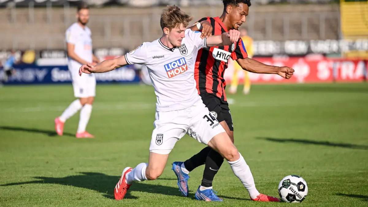 SSV Ulm 1846 - SV Elversberg: 17.08.2025, Baden-Württemberg, Ulm: Fußball: DFB-Pokal, SSV Ulm 1846 - SV Elversberg, 1. Runde, Donaustadion. Jan Boller (l, SSV Ulm 1846 Fußball) in Aktion gegen Bambasé Conté (SV 07 Elversberg). Foto: Harry Langer/dpa - WICHTIGER HINWEIS: Gemäß den Vorgaben der DFL Deutsche Fußball Liga bzw. des DFB Deutscher Fußball-Bund ist es untersagt, in dem Stadion und/oder vom Spiel angefertigte Fotoaufnahmen in Form von Sequenzbildern und/oder videoähnlichen Fotostrecken zu verwerten bzw. verwerten zu lassen. +++ dpa-Bildfunk +++
