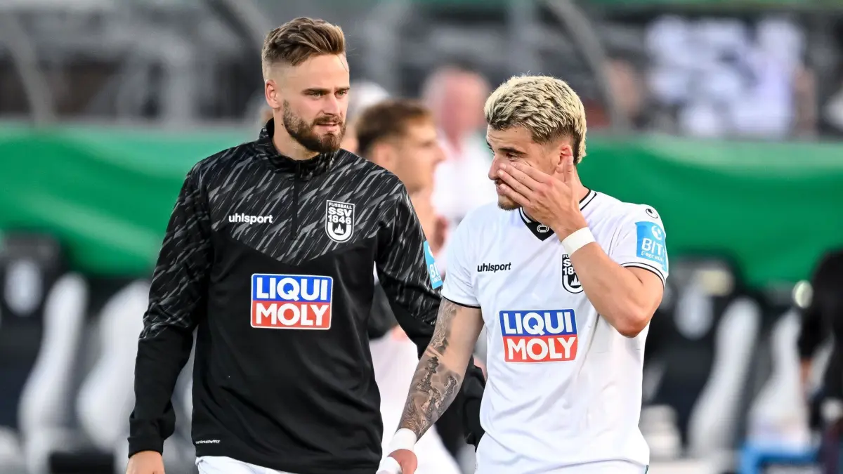 SSV Ulm 1846 - SV Elversberg: 17.08.2025, Baden-Württemberg, Ulm: Fußball: DFB-Pokal, SSV Ulm 1846 - SV Elversberg, 1. Runde, Donaustadion. Lucas Röser (l, SSV Ulm 1846 Fußball) und Niklas Castelle (SSV Ulm 1846 Fußball) reagieren nach dem Spiel unzufrieden. Foto: Harry Langer/dpa - WICHTIGER HINWEIS: Gemäß den Vorgaben der DFL Deutsche Fußball Liga bzw. des DFB Deutscher Fußball-Bund ist es untersagt, in dem Stadion und/oder vom Spiel angefertigte Fotoaufnahmen in Form von Sequenzbildern und/oder videoähnlichen Fotostrecken zu verwerten bzw. verwerten zu lassen. +++ dpa-Bildfunk +++