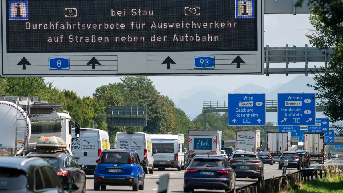 Durchfahrtsverbote für Ausweichverkehr bei Stau: 15.08.2025, Bayern, Raubling: Eine Informationstafel über der A8 weist vor dem Inntal-Dreieck den Verkehr auf Durchfahrtsverbote auf Nebenstrecken bei Stau hin. Die Sperrungen bestimmter Strecken entlang der A8 südlich von München Richtung Salzburg und auf der A93 im Inntal sind immer von Freitag bis Sonntag und an Feiertagen geplant. Die Kommunen wollen damit den Verkehr reduzieren, der an verkehrsreichen Tagen durch ihre Ortschaften fließt und dort ebenfalls für Stau sorgt. (zu dpa: «Etliche Verstöße gegen Abfahrverbote an A8 und A93») Foto: Stefan Puchner/dpa +++ dpa-Bildfunk +++