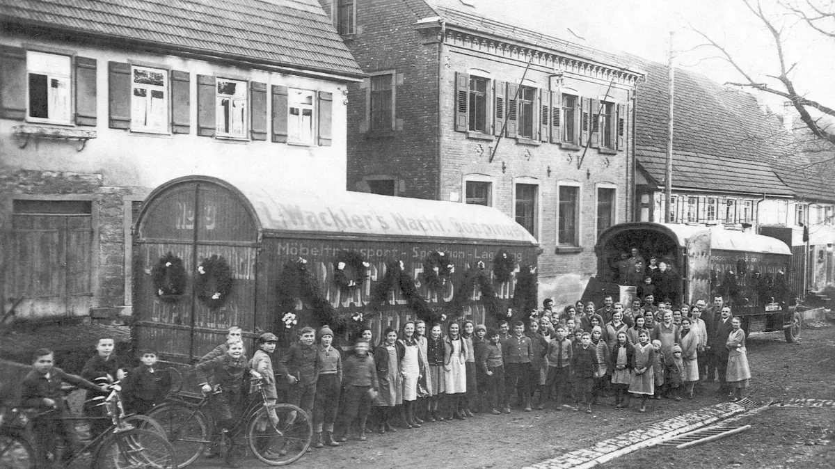 Ein historisches Foto vom Schulhaus aus dem Jahr 1933. Schulmeister Rauscher muss Oberwälden verlassen. Kinder des Dorfes haben den Umzugswagen geschmückt.