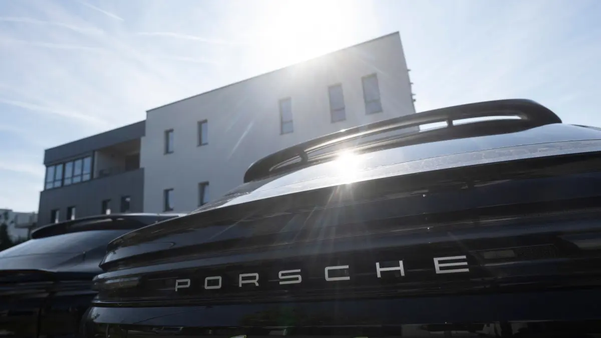 Porsche will Batterie-Tochter weitgehend abwickeln: 25.08.2025, Baden-Württemberg, Kirchentellinsfurt: Ein Porsche steht während einer Betriebsversammlung vor dem Sitz des Batterie-Unternehmens Cellforce auf einem Parkplatz. Der Sportwagenbauer Porsche will sein Tochterunternehmen Cellforce weitgehend einstellen. Foto: Marijan Murat/dpa +++ dpa-Bildfunk +++