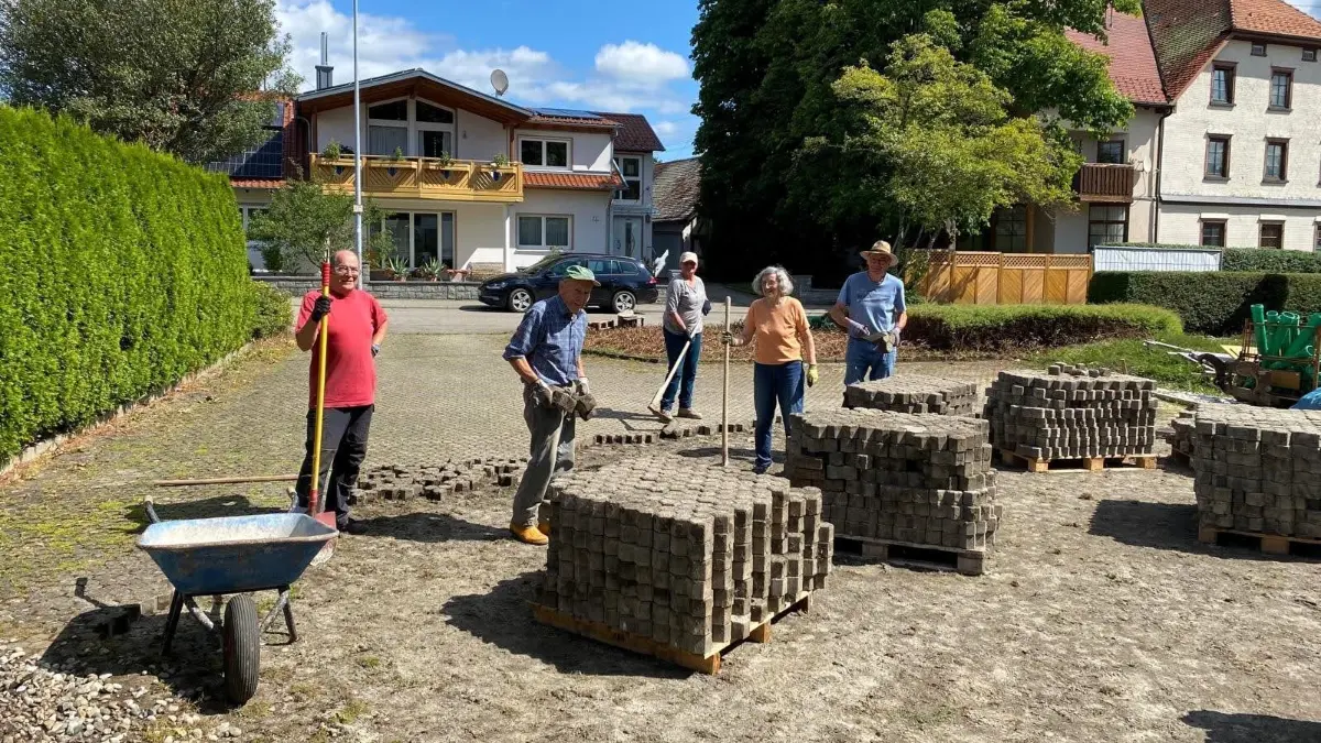 Von wegen Sommerferien: Fleißige Kirchenmitglieder haben vor dem Gemeindehaus Pflastersteine ausgebaut.