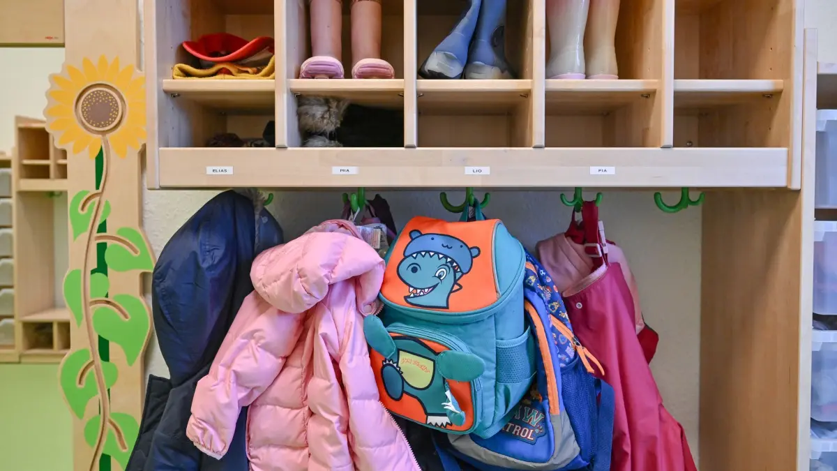 Zahl der Kindergartenkinder nimmt ab: ARCHIV - 22.12.2023, Brandenburg, Spremberg: Kleidung von Kindern hängt in einer Kita. (zu dpa: «Verband sieht Sterben der Tagespflege in Brandenburg») Foto: Patrick Pleul/dpa +++ dpa-Bildfunk +++