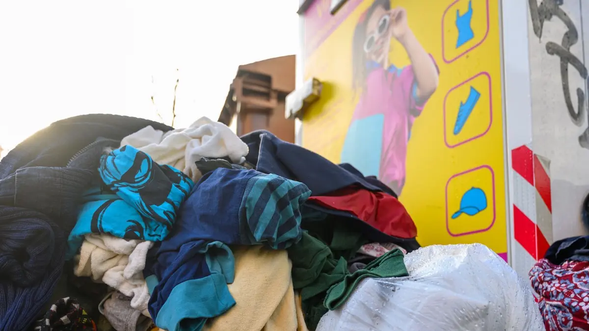Altkleider: ARCHIV - 08.01.2025, Sachsen, Leipzig: Gebrauchte Kleidungsstücke liegen vor einem Sammelcontainer für Altkleider in Leipzig. (zu dpa: «Neue EU-Regeln gegen Lebensmittel- und Kleidungsmüll») Foto: Hendrik Schmidt/dpa +++ dpa-Bildfunk +++