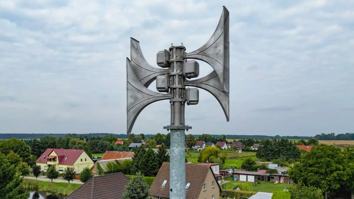 04.09.2025, Brandenburg, Petersdorf: Eine Sirene ist über den Hausdächern in einem Ort zu sehen (Luftaufnahme mit einer Drohne). Wenn das Smartphone am 11.09.2025 um 11 Uhr plötzlich laut klingelt und in der Ferne die Sirenen heulen, müssen die Menschen in Deutschland nicht erschrecken: Es besteht keine Gefahr, sondern es ist wieder bundesweiter Warntag. Ziel des Warntages, welcher seit 2020 in ganz Deutschland durchgeführt wird, ist unter anderem die technische Erprobung der Informationswege. Des Weiteren soll die Bevölkerung auf die Warnmittel und für Ernstfälle sensibilisiert werden. Foto: Patrick Pleul/dpa +++ dpa-Bildfunk +++