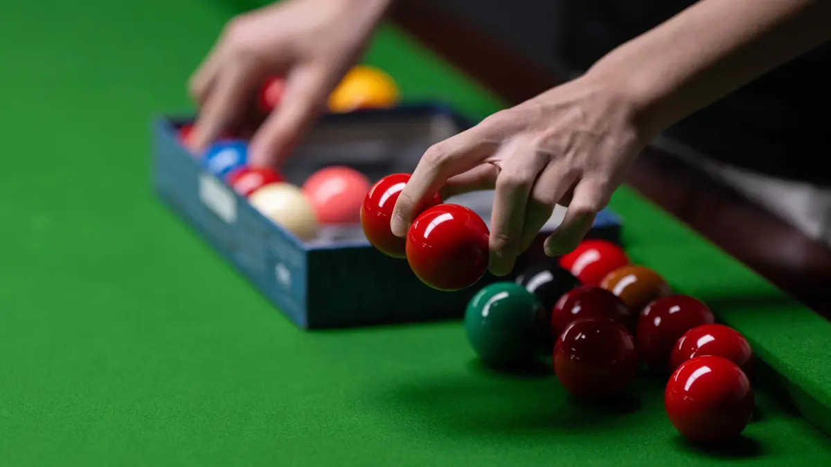 Chinese professional snooker player Lan Yuhao sets up snooker balls to pot as he practices in the Ding Junhui Snooker Academy in the centre of Sheffield, northern England on September 10, 2025. Since 1977 the Snooker World Championship has been held every year in Sheffield's 980-seat Crucible Theatre, with an estimated 500 million spectators watching the televised broadcast across 150 countries. China's Zhao Xintong is the reigning World Snooker Champion, the first Asian player to win the title, whilst China's Bai Yulu is the reigning winner of the World Women's Snooker Championship. Snooker remains incredibly popular in China, with around 50 million people playing the game and approximately 300,000 snooker clubs, however many professional Chinese players are based in Sheffield, England as the widely-acknowledged home of the sport. (Photo by Oli SCARFF / AFP)