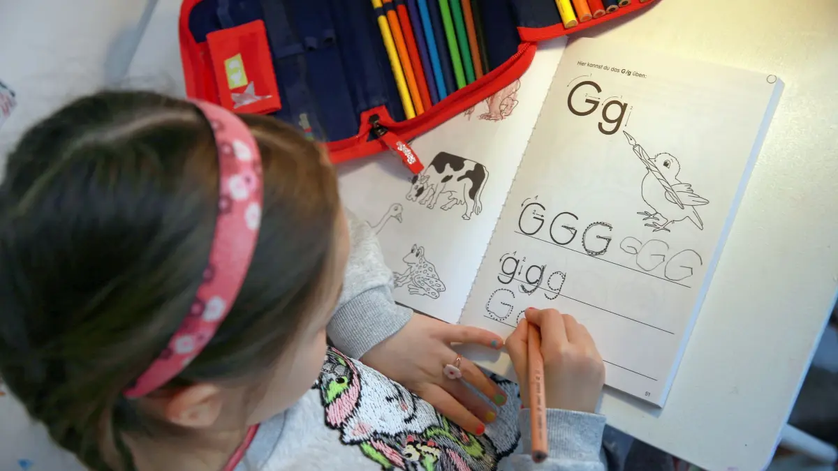 Ein Mädchen lernt Schreiben: ILLUSTRATION - Was ist der Vorteil vom Schreiben mit Stift auf Papier? Es fördert laut einem Wissenschaftler buchstäbliches Begreifen einzelner Zeichen und rasches Kombinieren oder Entziffern von Buchstabengruppen. (zu dpa: «Warum überhaupt noch mit dem Stift schreiben lernen?») Foto: Mascha Brichta/dpa-tmn - Honorarfrei nur für Bezieher des dpa-Themendienstes +++ dpa-Themendienst +++