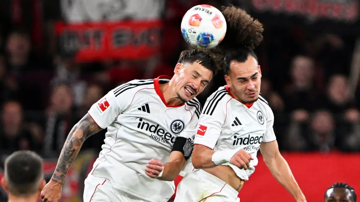 Bayer Leverkusen - Eintracht Frankfurt: 12.09.2025, Nordrhein-Westfalen, Leverkusen: Fußball: Bundesliga, Bayer Leverkusen - Eintracht Frankfurt, 3. Spieltag, BayArena, Robin Koch (Eintracht Frankfurt, l) und Arthur Theate (Eintracht Frankfurt) steigen zum Kopfball hoch. WICHTIGER HINWEIS: Gemäß den Vorgaben der DFL Deutsche Fußball Liga bzw. des DFB Deutscher Fußball-Bund ist es untersagt, in dem Stadion und/oder vom Spiel angefertigte Fotoaufnahmen in Form von Sequenzbildern und/oder videoähnlichen Fotostrecken zu verwerten bzw. verwerten zu lassen. Foto: Federico Gambarini/dpa +++ dpa-Bildfunk +++