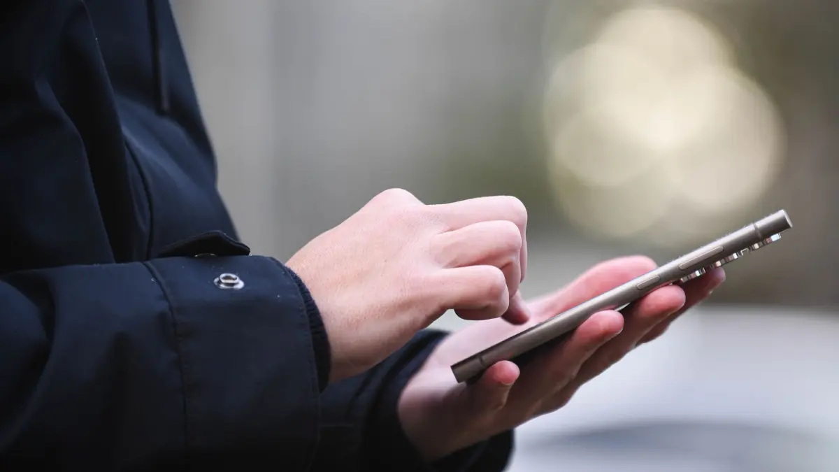 Frau tippt auf einem Smartphone