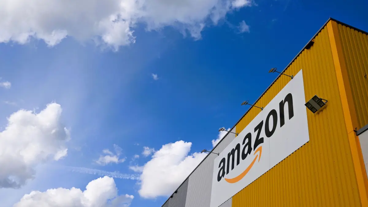 Amazon-Logistikhalle: PRODUKTION - 14.09.2025, Nordrhein-Westfalen, Dortmund: Container des Logistikers und Paketunternehmens DHL, das an der Börse Deutsche Post AG heißt, stehen vor dem Logistikzentrum von Amazon. DHL befördert Pakete für den US-Händler. (zu dpa: «Amazon fährt Investitionen in Deutschland hoch») Foto: Wolf von Dewitz/dpa +++ dpa-Bildfunk +++