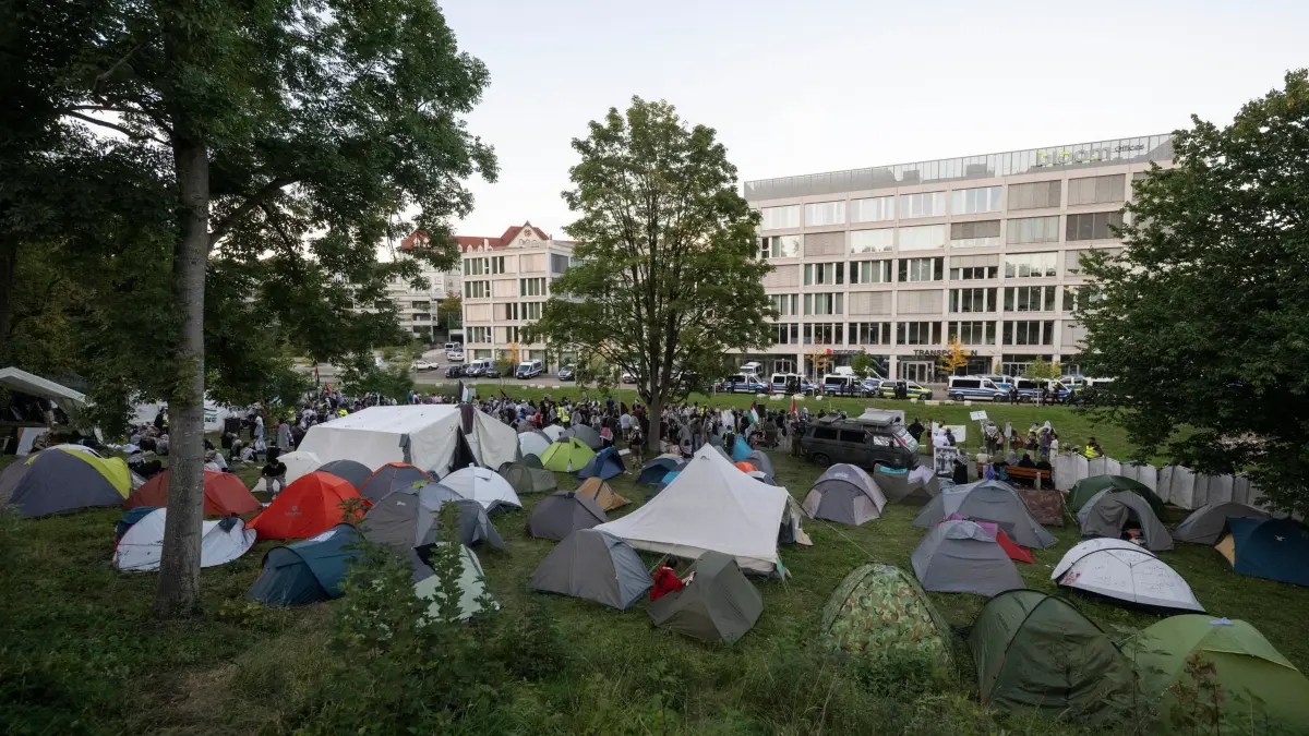 Protestcamp gegen israelische Rüstungsfirma in Ulm: 20.09.2025, Baden-Württemberg, Ulm: Zelte stehen auf einem Protestcamp vor einem Bürogebäude, in dem sich unter anderem Räume des Rüstungskonzerns Elbit Systems befinden. Auf der Wiese campieren seit Tagen Menschen in Zelten. Nach dem Anschlag auf ein israelisches Rüstungsunternehmen in Ulm setzen sich propalästinensische Protestaktionen gegen den Gaza-Krieg fort. Foto: Marijan Murat/dpa +++ dpa-Bildfunk +++