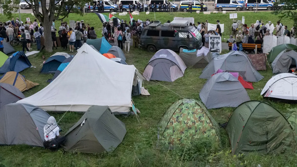 Protestcamp gegen israelische Rüstungsfirma in Ulm: 20.09.2025, Baden-Württemberg, Ulm: Zelte stehen auf einem Protestcamp vor einem Bürogebäude, in dem sich unter anderem Räume des Rüstungskonzerns Elbit Systems befinden. Auf der Wiese campieren seit Tagen Menschen in Zelten. Nach dem Anschlag auf ein israelisches Rüstungsunternehmen in Ulm setzen sich propalästinensische Protestaktionen gegen den Gaza-Krieg fort. Foto: Marijan Murat/dpa +++ dpa-Bildfunk +++