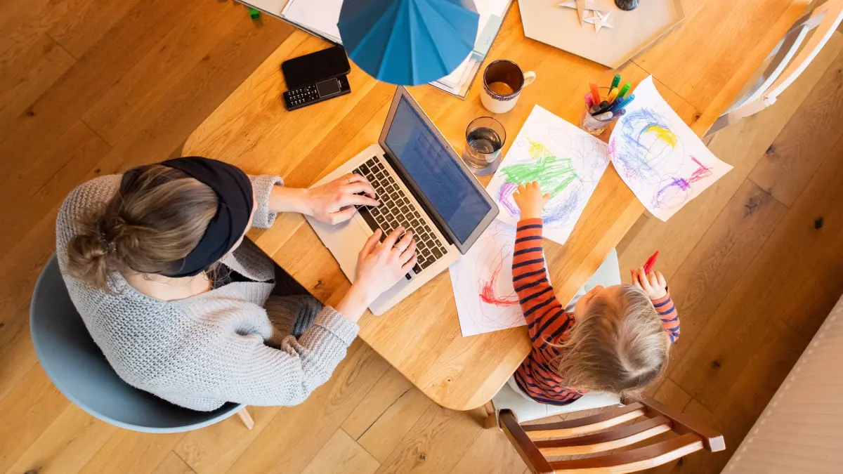 Eine Frau arbeitet im Homeoffice mit Kind: ARCHIV - 20.01.2021, Niedersachsen, Hannover: Der Anteil der Mütter, die ihren Lebensunterhalt überwiegend aus eigener Erwerbstätigkeit finanzieren, ist in Bayern gestiegen. (zu dpa: «Homeoffice bleibt beliebt - aber Arbeitnehmer öfter im Büro») Foto: Julian Stratenschulte/dpa +++ dpa-Bildfunk +++