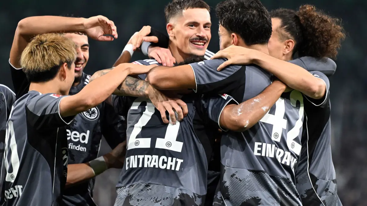 Borussia Mönchengladbach - Eintracht Frankfurt: 27.09.2025, Nordrhein-Westfalen, Mönchengladbach: Fußball: Bundesliga, Borussia Mönchengladbach - Eintracht Frankfurt, 5. Spieltag, Stadion im Borussia-Park, Robin Koch (M, Eintracht Frankfurt) bejubelt sein Tor zum 0:6 mit seinen Mitspielern. Foto: Federico Gambarini/dpa - WICHTIGER HINWEIS: Gemäß den Vorgaben der DFL Deutsche Fußball Liga bzw. des DFB Deutscher Fußball-Bund ist es untersagt, in dem Stadion und/oder vom Spiel angefertigte Fotoaufnahmen in Form von Sequenzbildern und/oder videoähnlichen Fotostrecken zu verwerten bzw. verwerten zu lassen. +++ dpa-Bildfunk +++