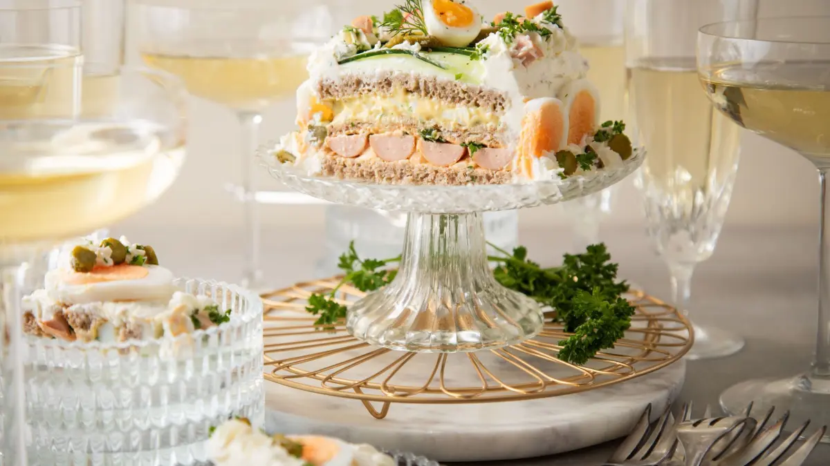 Brottorte mit Eiersalat, Wiener Würstchen und Obazda-Füllung: ILLUSTRATION - Schicht für Schicht zur Brottorte: Mit Eiersalat, Wiener Würstchen und Obazda-Füllung sorgt die viereckige Torte für Bewunderung. (zu dpa: «Brottorten: Warum süß, wenn's auch herzhaft lecker ist?») Foto: Christin Klose/dpa-tmn - Honorarfrei nur für Bezieher des dpa-Themendienstes +++ dpa-Themendienst +++