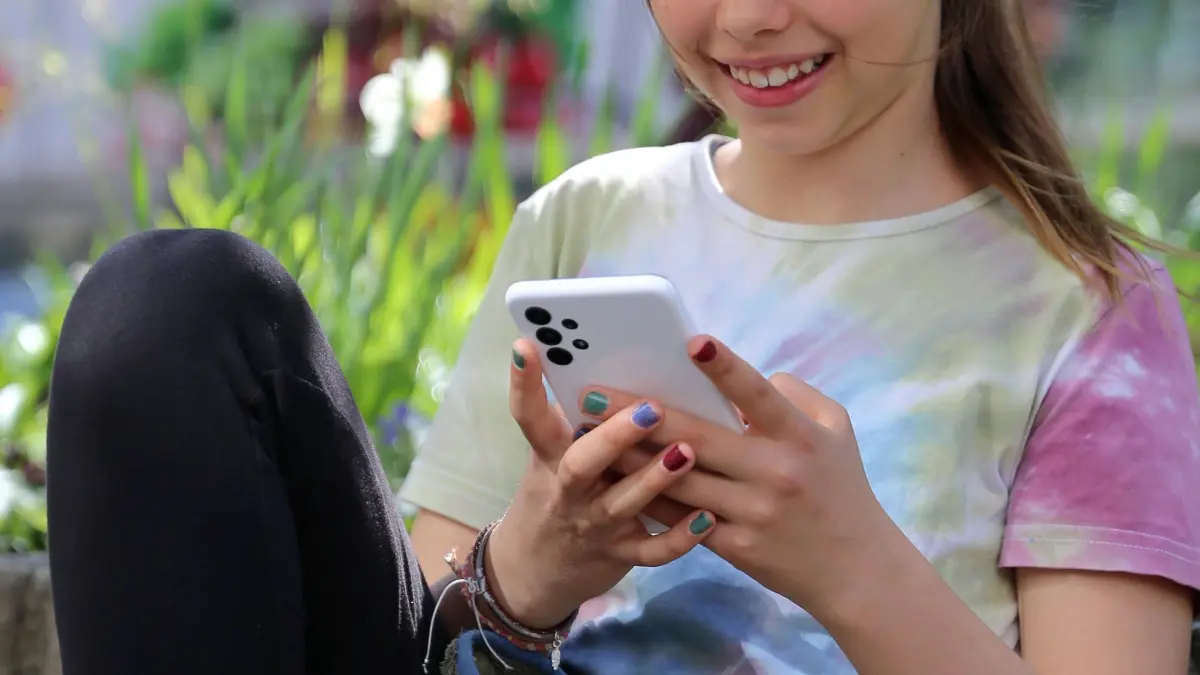 Ein Mädchen mit Smartphone: ILLUSTRATION - Kinder und Jugendliche nutzen wie auch Erwachsene Handy, Streaming & Co. zum Entspannen. (zu dpa: «Guck mal da! Was Eltern und Kinder über Medien lernen können») Foto: Mascha Brichta/dpa-tmn - Honorarfrei nur für Bezieher des dpa-Themendienstes +++ dpa-Themendienst +++