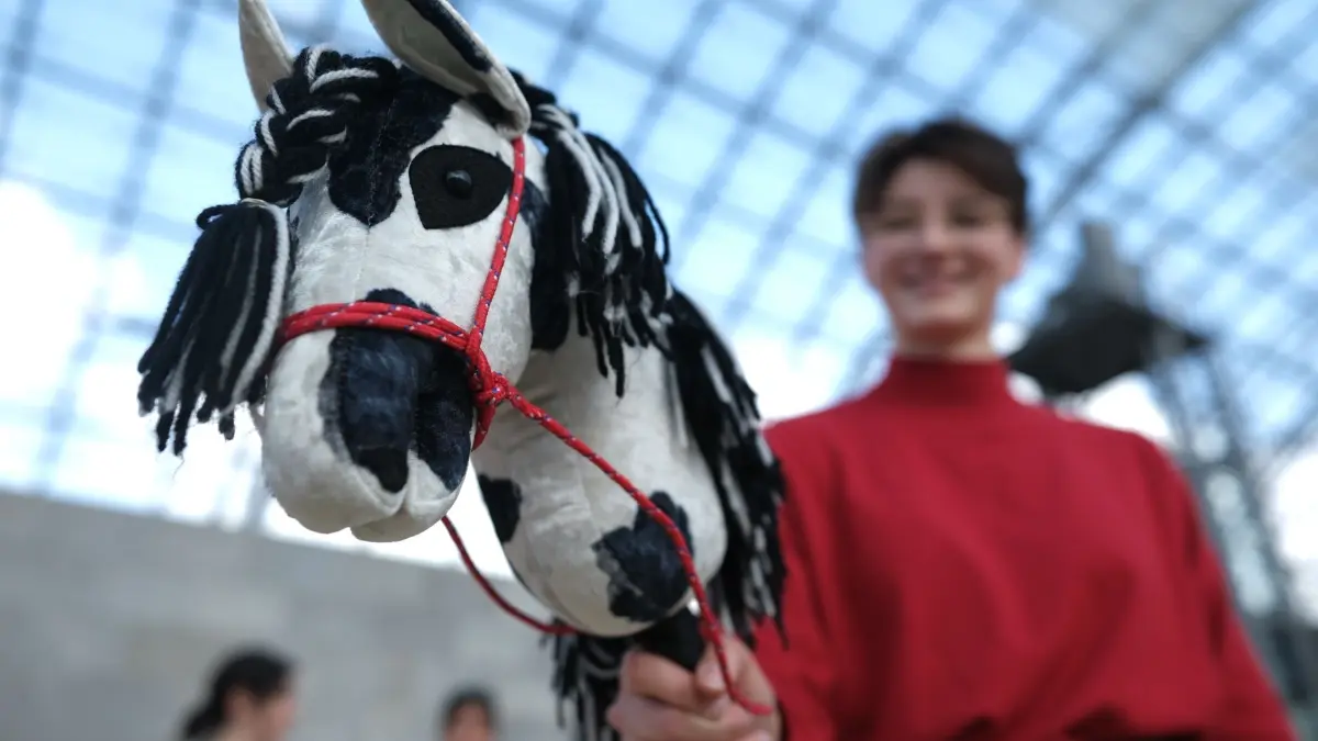 Hobbymesse Leipzig: ARCHIV - 02.10.2025, Sachsen, Leipzig: Eine junge Frau hält beim Fototermin in der Glashalle der Neuen Messe ein Hobby-Horsing-Pferd. Zur Leipziger Hobbymesse, die vom 03.10. bis zum 05.10.2025 stattfindet, wird das größte Hobby-Horsing-Turnier Sachsens ausgetragen. (zu dpa: «Dickes Besucherplus bei der Leipziger Hobbymesse») Foto: Sebastian Willnow/dpa +++ dpa-Bildfunk +++