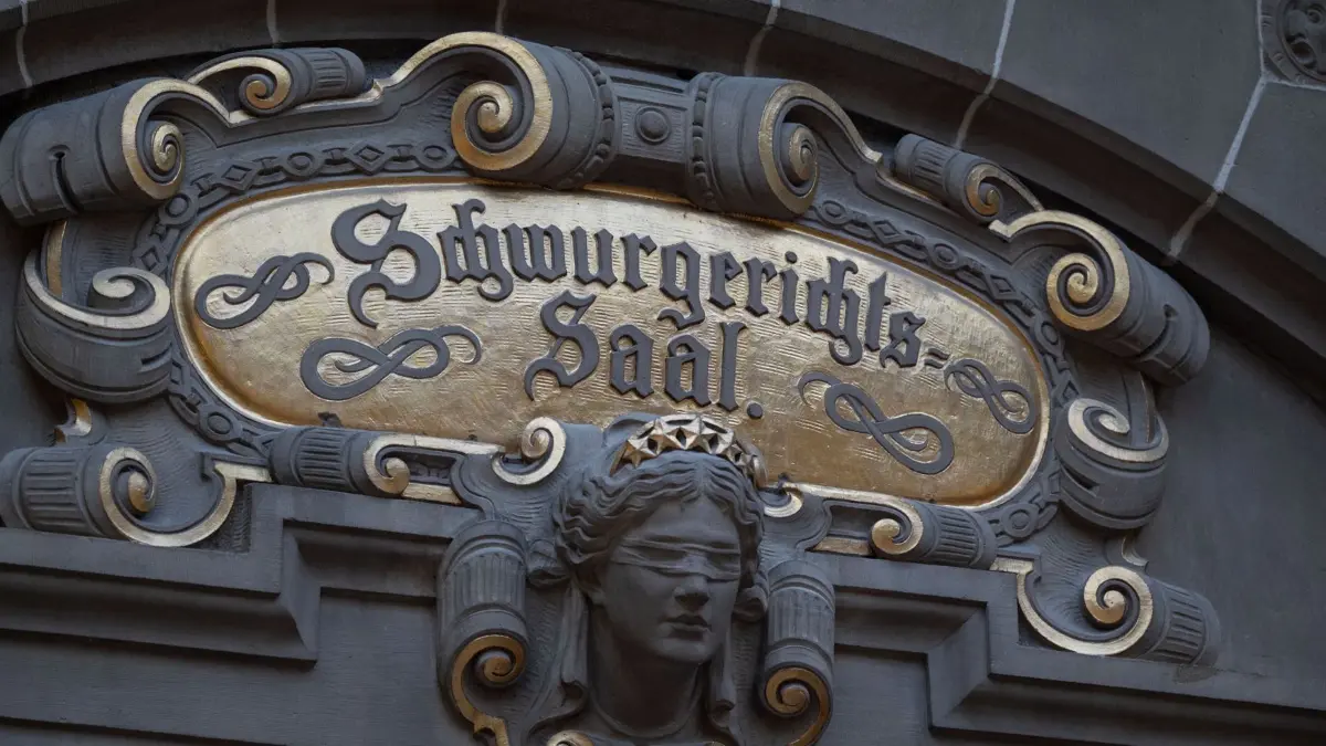 ARCHIV - 09.02.2022, Baden-Württemberg, Tübingen: Ein Schild weist auf den Schwurgerichtssaal im Justizgebäude, in dem sich das Amtsgericht und das Landgericht Tübingen befinden, hin. (zu dpa: «Prozess: Mann aus Fenster gestoßen und vergewaltigt») Foto: Marijan Murat/dpa +++ dpa-Bildfunk +++