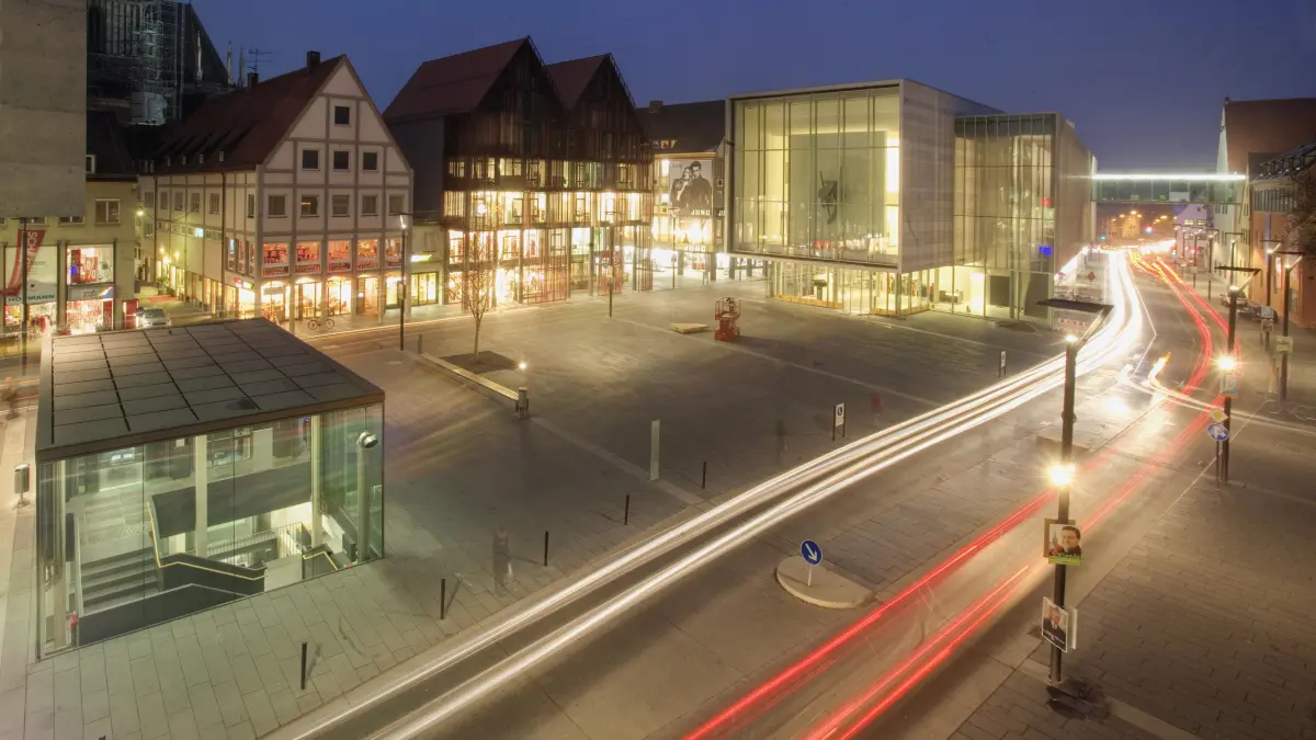 Ulm, Neue Mitte, Hans-und-Sophie-Scholl-Platz: Lichtblick Neue Mitte: Der Hans-und-Sophie-Scholl-Platz am Abend, erleuchtet durch die Kunsthalle Weishaupt und das Doppel-Giebelhaus der Museumsgesellschaft.