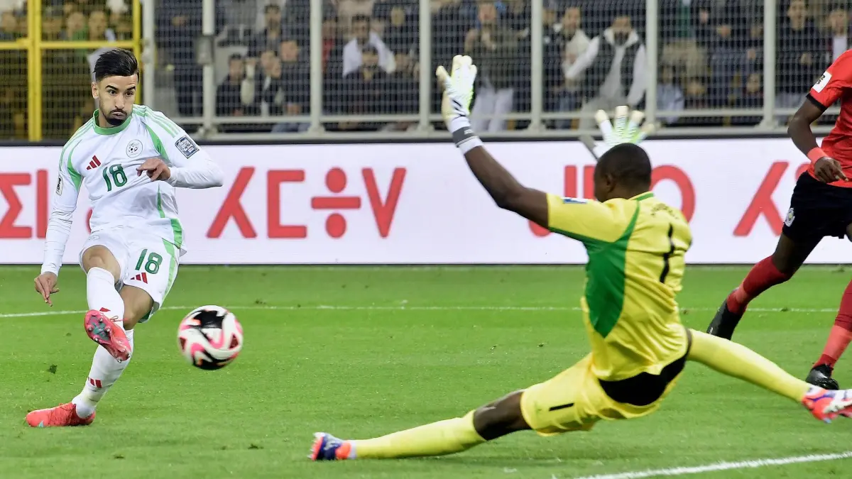 Mohamed Amoura: ARCHIV - 25.03.2025, Algerien, Tizi Ouzou: Fußball: WM-Qualifikation Afrika, Algerien - Mosambik, Gruppenphase, Gruppe G, 6. Spieltag. Algeriens Mohamed Amoura schießt aufs Tor, während Mosambiks Torhüter Ernan Siluane den Ball verfehlt. (zu dpa: «Dank Wolfsburgs Amoura: Algerien zum fünften Mal bei der WM») Foto: Fateh Guidoum/AP/dpa +++ dpa-Bildfunk +++