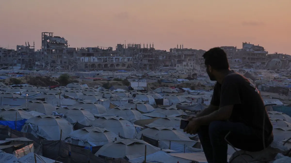 25.07.2025, Palästinensische Gebiete, Gaza: Illustration - Ein Palästinenser betrachtet ein behelfsmäßiges Zeltlager für Menschen, die durch die israelischen Luft- und Bodenoperationen im Gazastreifen vertrieben wurden, während die Sonne in Gaza-Stadt untergeht. In Ägypten haben die Konfliktparteien zuletzt indirekt über Einzelheiten eines US-Plans zur Beendigung des Gaza-Kriegs verhandelt. Laut US-Präsident Trump hat es dabei einen Durchbruch gegeben. Foto: Abdel Kareem Hana/AP/dpa +++ dpa-Bildfunk +++