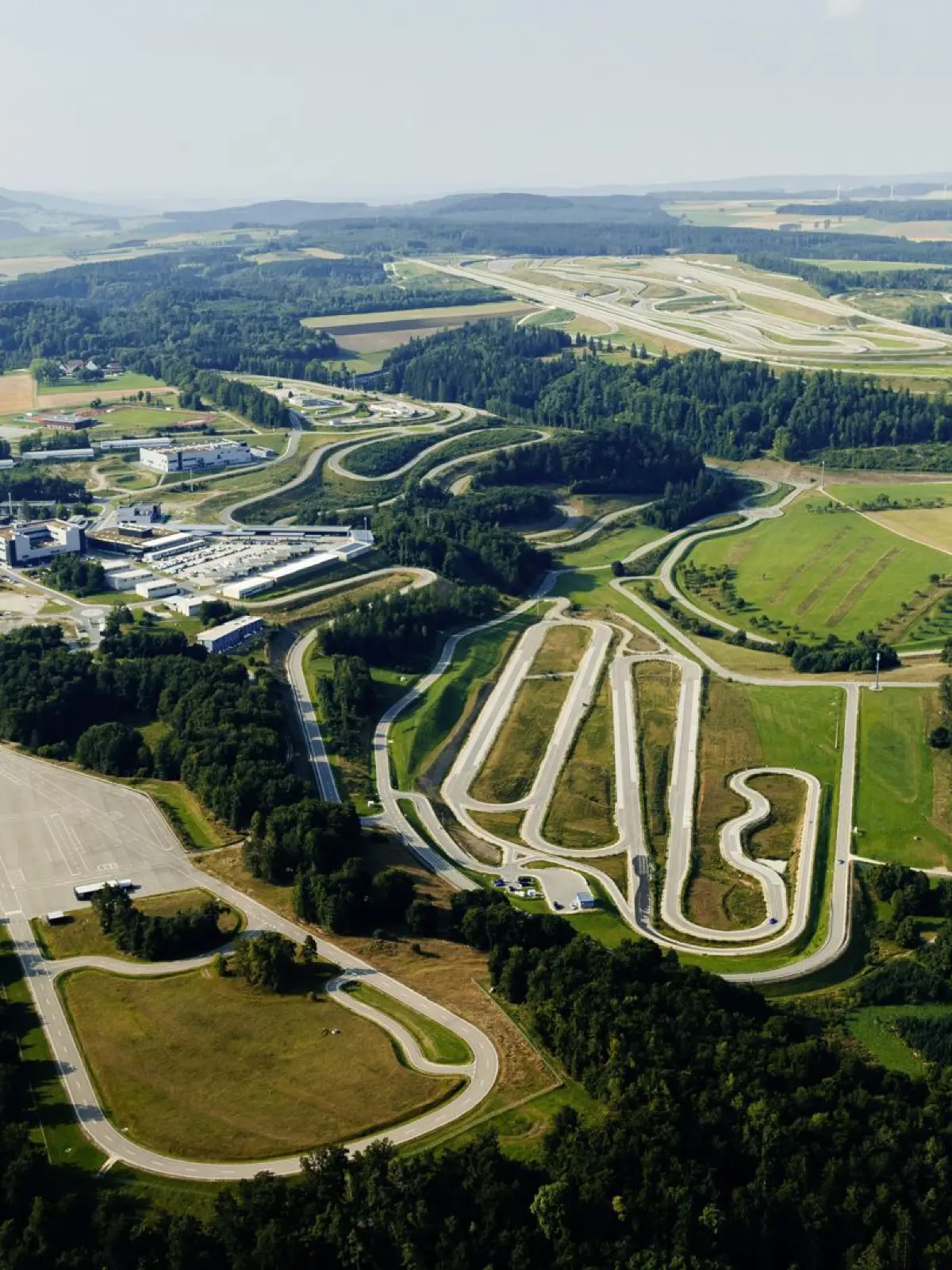Ãbersicht-Fotos des Mercedes-Benz Prüf- und Technologiezentrum Immendingen. Mercedes-Benz Prüf- und Technologiezentrum Immendingen: Das Prüfgelände in Immendingen bietet auf 520 Hektar mehr als 30 Testmodule mit 86 Kilometern Fahrstrecke und 256 Abzweigungen. Es bildet die reale Verkehrswelt in vielfältigen Varianten ab und ermöglicht Tests mit bis zu 400 Fahrzeugen gleichzeitig.
//
Mercedes-Benz Test and Technology Centre Immendingen: The test site in Immendingen offers more than 30 test modules with 86 kilometres of driving distance and 256 junctions on 520 hectares. It depicts the real world of traffic in a wide range of variants and enables tests with up to 400 vehicles at the same time.