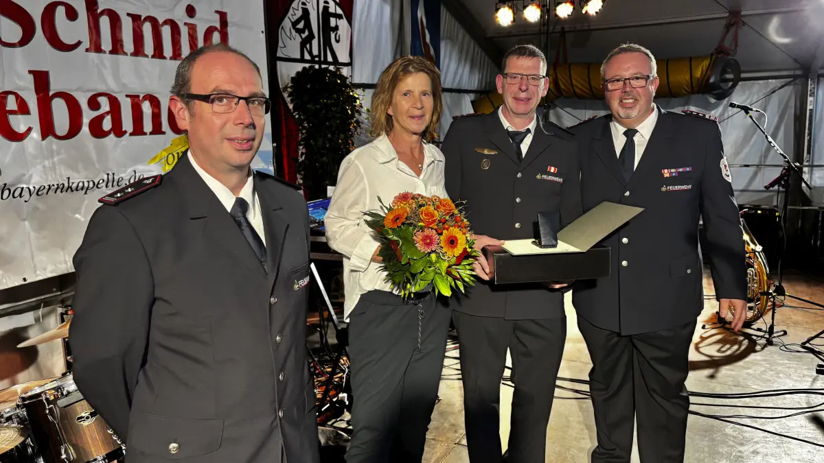 Ehrung Patrick Hörner, Türkheim, Löschzugführer - Neben ihm steht seine Ehefrau, rechts von ihm der Kommandant Andreas Baumholzer und ganz links dessen Stellvertreter, Michael Schilling.
