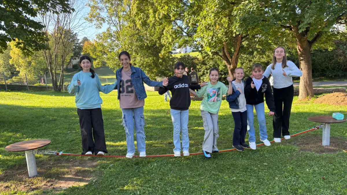 Neben Holzsofas und einer großen Sitzgelegenheit in U-Form gehört auch eine Slackline zur Ausstattung des grünen Klassenzimmers im Schulgarten.