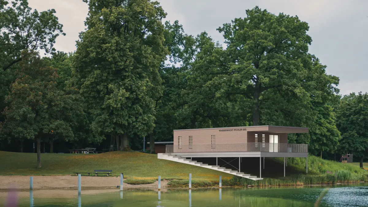 Ein zweckmäßiger Holzbau, der sich ohne großen Eingriff ins Seeufer einfügt: Hier kommt die Wasserwacht ab 2027 am Pfuhler See unter.