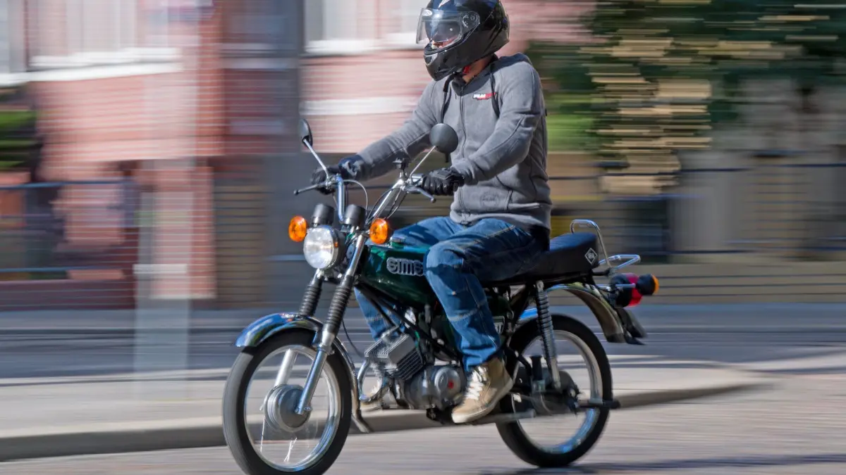 Für Mofas und E-Scooter ist 2024 ein blaues Kennzeichen Pflicht: ARCHIV - 25.07.2018, Sachsen-Anhalt, Halle (Saale): Mit einem fast 40 Jahre alten Versicherungskennzeichen ist ein 15-Jähriger auf einem Mofa unterwegs gewesen. (zu dpa: «Vier Jugendliche stürzen mit Moped – zwei schwer verletzt») Foto: Hendrik Schmidt/dpa-Zentralbild/dpa +++ dpa-Bildfunk +++