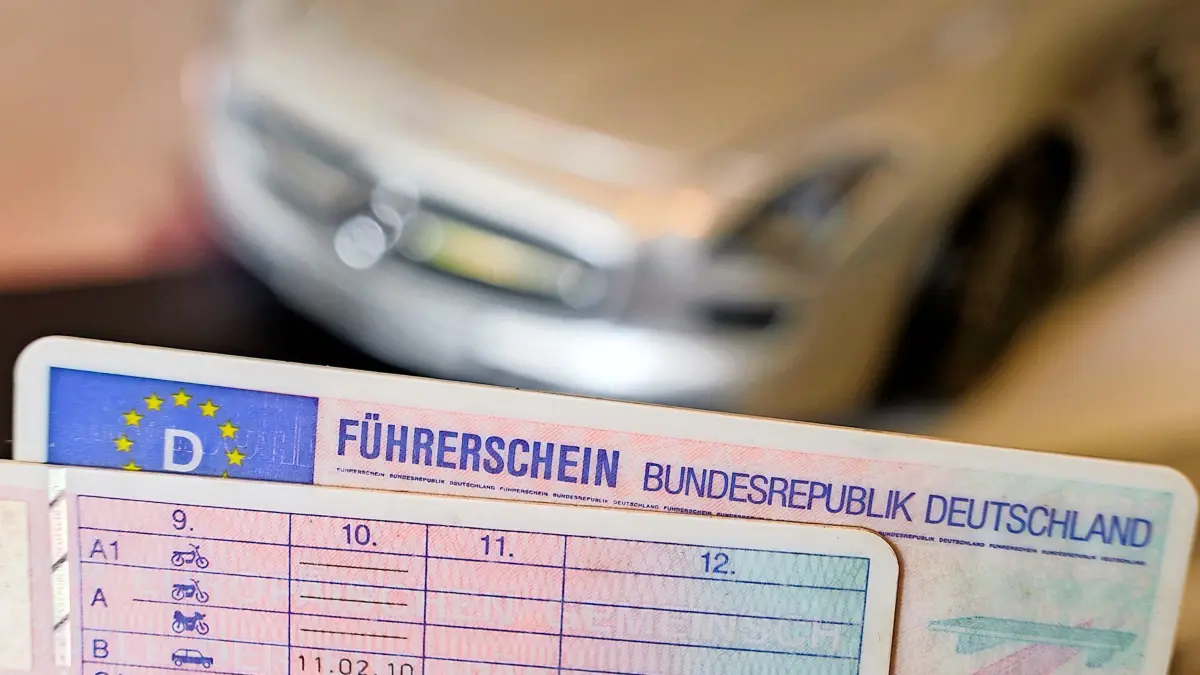 ARCHIV - 06.10.2021, Niedersachsen, Hannover: ILLUSTRATION - Zwei Führerscheine liegen vor einem Modellauto auf einem Tisch (gestellte Szene). Der verpflichtende Führerschein-Umtausch stellt die Führerscheinstellen in Sachsen-Anhalt vor eine erhebliche Belastungsprobe. (zu dpa «Umtausch von Führerscheinen: Kreise und Städte werden Frist verfehlen») Foto: Ole Spata/dpa +++ dpa-Bildfunk +++