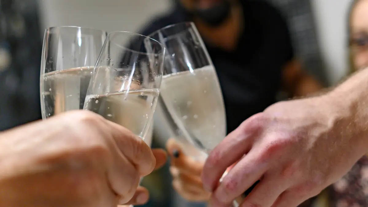 Mehrere Personen halten Sektgläser in den Händen: ARCHIV - Eine Runde Sekt für die Mitarbeiter - nett, wenn der Chef das erlaubt. Die Arbeitsfähigkeit darf das aber nicht beeinträchtigen. (zu dpa: «Alkohol am Arbeitsplatz – was geht und was nicht») Foto: Daniel Maurer/dpa-tmn - Honorarfrei nur für Bezieher des dpa-Themendienstes +++ dpa-Themendienst +++