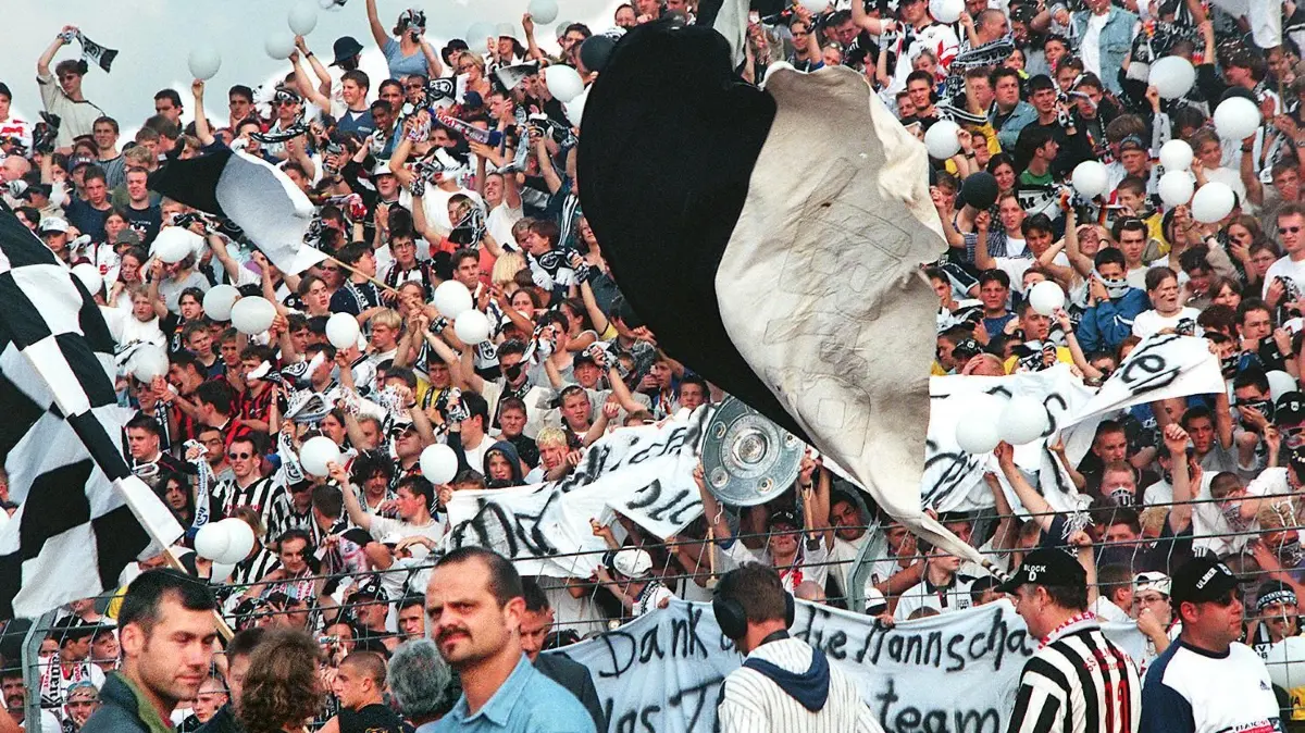 Ulm, 2. Bundesliga, SSV Ulm 1846 - SpVgg Greuther Fürth (0:0): Die Ulmer Fans schwenken weiß-schwarze Fahnen. Der SSV Ulm 1846 spielt in der kommenden Saison in der 1. Bundesliga. Am letzten Spieltag der 2. Liga reichte dem SSV zu Hause gegen Greuther Fürth ein torloses Unentschieden, um den Durchmarsch ins Oberhaus zu schaffen. Beachten: Titelbild von der Neckarchronik und der Rundschau.
