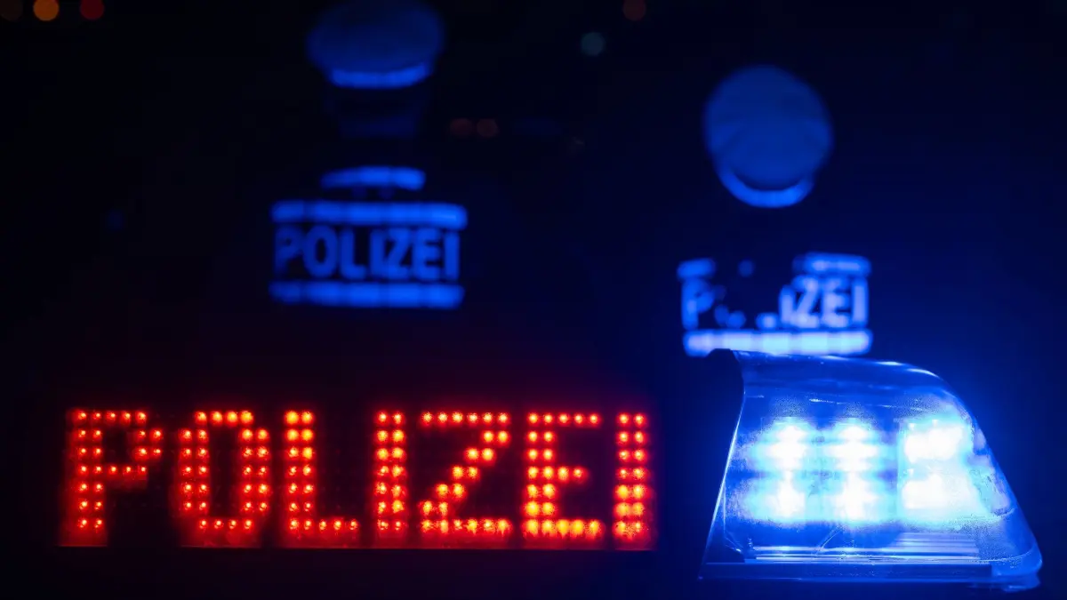 Zwei Polizisten stehen vor einem Streifenwagen: ILLUSTRATION - 30.11.2023, Baden-Württemberg, Stuttgart: Zwei Polizisten stehen vor einem Streifenwagen. (zu dpa: «Verfolgungsfahrt endet in Fluss – Führerschein beschlagnahmt») Foto: Marijan Murat/dpa +++ dpa-Bildfunk +++