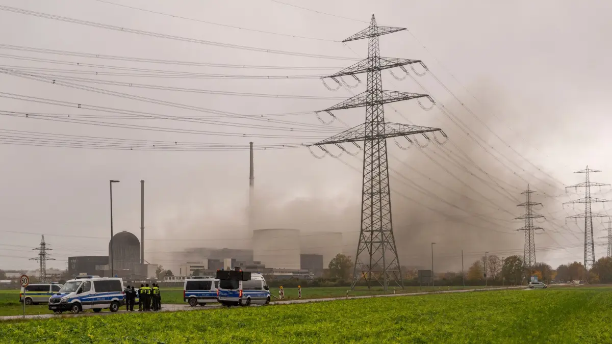 Sprengung Kühltürme Kernkraftwerk Gundremmingen: 25.10.2025, Bayern, Gundremmingen: Nach der Sprengung des beiden Kühltürme des stillgelegten Kernkraftwerks zieht eine Staubwolke über das Gelände. Foto: Stefan Puchner/dpa +++ dpa-Bildfunk +++