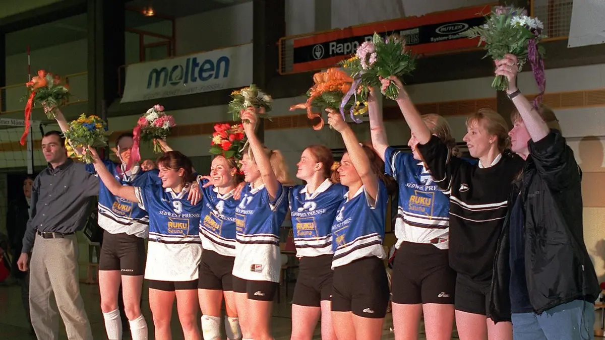 Ulm, SSV Ulm 1846, Mannschaft, Jubel über den Aufstieg in die Bundesliga: Die Volleyballdamen haben den Aufstieg in die Bundesliga geschafft. Die Mannschaft steht in einer Reihe und winkt mit Blumensträußen.