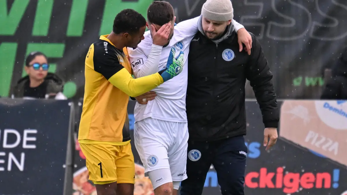 Verbandsliga, 13. Spieltag, Young Boys Reutlingen - TSV Berg: Verbandsliga, 13. Spieltag, Young Boys Reutlingen - TSV Berg, 26.10.2025 - Ante Galic (Young Boys, Mitte) muss mit einer schweren Verletzung vom Platz - Gäste-Torhüter Ande Port (Berg, links) tröstet
Foto: Axel Grundler