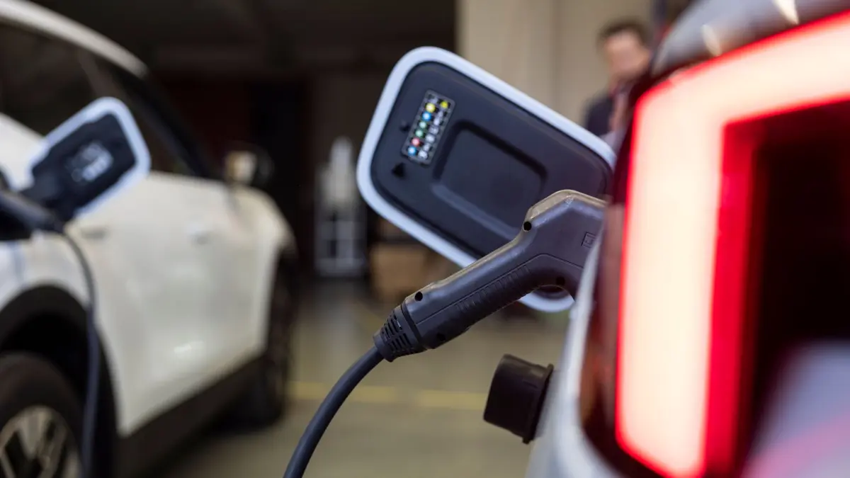 E-Autos als mobile Energiespeicher für Haus und Stromnetz: PRODUKTION - 15.10.2025, Rheinland-Pfalz, Mainz: Ein Ladestecker steckt in einem Auto in einer Halle von der Firma Ambibox. Die Firma baut bidirektionale Ladesysteme. (zu dpa: «E-Autos als mobile Energiespeicher für Haus und Stromnetz») Foto: Hannes P Albert/dpa +++ dpa-Bildfunk +++