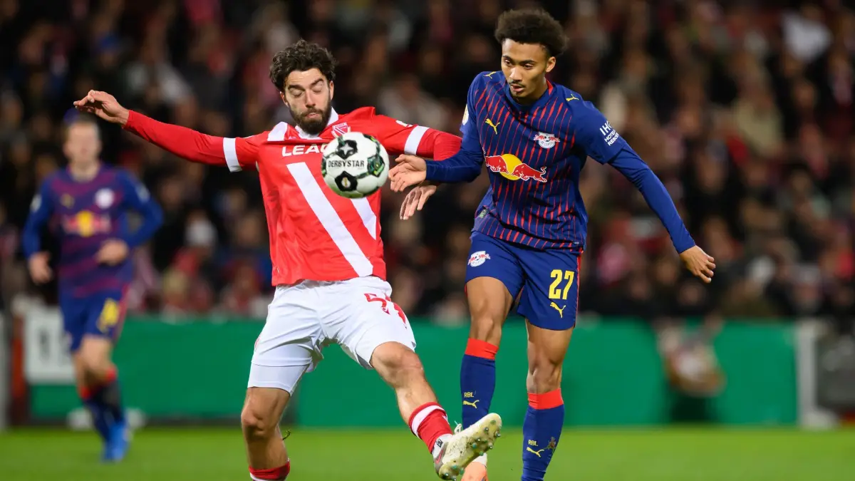 FC Energie Cottbus - RB Leipzig: 28.10.2025, Brandenburg, Cottbus: Fußball: DFB-Pokal, FC Energie Cottbus - RB Leipzig, 2. Runde, LEAG Energie Stadion, Dominik Pelivan (Energie Cottbus, l) gegen Tidiam Gomis (RB Leipzig). Foto: Robert Michael/dpa - WICHTIGER HINWEIS: Gemäß den Vorgaben der DFL Deutsche Fußball Liga bzw. des DFB Deutscher Fußball-Bund ist es untersagt, in dem Stadion und/oder vom Spiel angefertigte Fotoaufnahmen in Form von Sequenzbildern und/oder videoähnlichen Fotostrecken zu verwerten bzw. verwerten zu lassen. +++ dpa-Bildfunk +++