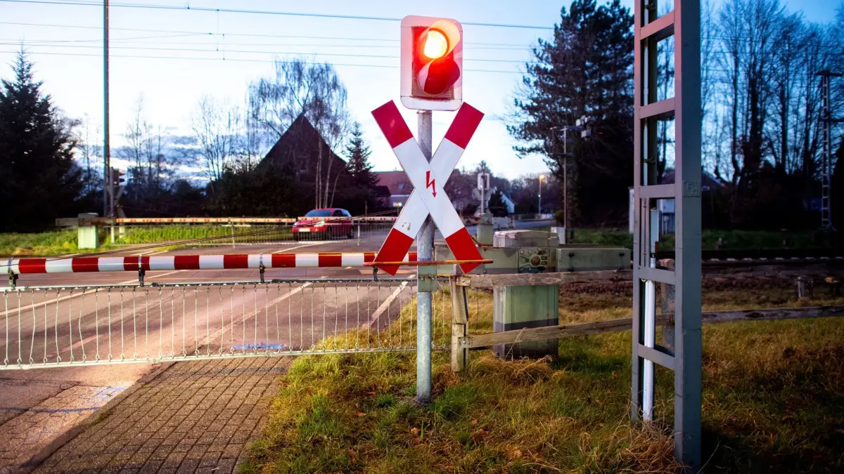 Bauprojekt: ARCHIV - 15.12.2021, Niedersachsen, Ihrhove: Eine Ampel an einem Bahnübergang an der zweigleisigen Bahnstrecke leuchtet vor einer Zugdurchfahrt rot. (zu dpa: «Mann montiert Bahnschranke nach Störung selbst ab») Foto: Hauke-Christian Dittrich/dpa +++ dpa-Bildfunk +++