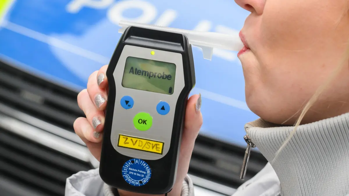 Atemalkoholtest - Symbolbild: PRODUKTION - 28.01.2025, Niedersachsen, Hannover: ILLUSTRATION - Eine Frau führt einen Alkoholtest (Atemtest) durch, mit dem sie auf ihre Fahrtüchtigkeit hin überprüft wird (gestellte Szene). (zu dpa: «Betrunkene Frau fährt rückwärts auf B10 und rammt Auto») Foto: Julian Stratenschulte/dpa +++ dpa-Bildfunk +++