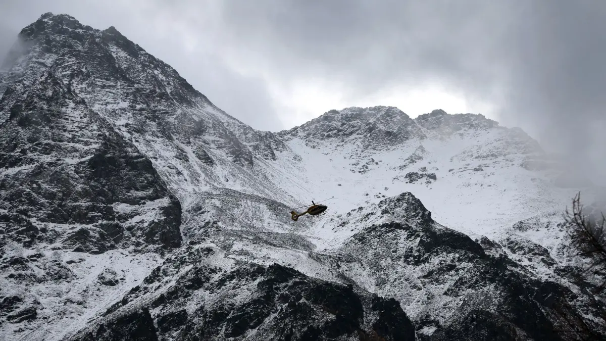 02.11.2025, Italien, Bozen: Ein Hubschrauber der Bergrettung fliegt auf der Suche nach zwei vermissten Bergsteigern vor dem mit Schnee bedeckten Ortler Gebirge. Nach dem Tod von mindestens drei deutschen Bergsteigern bei einem Lawinenunglück in Südtirol ist die Suche nach zwei Vermissten wieder aufgenommen worden. Foto: Karl-Josef Hildenbrand/dpa +++ dpa-Bildfunk +++