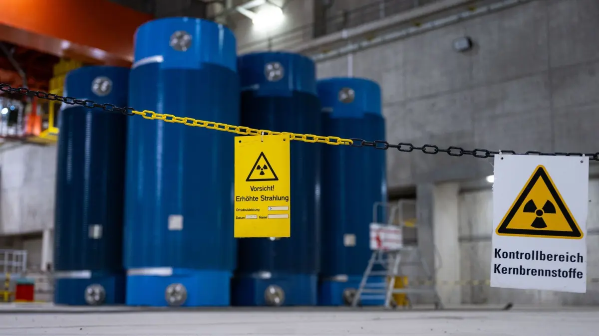 Atommüll Zwischenlager Ahaus: ARCHIV - 18.09.2025, Nordrhein-Westfalen, Ahaus: Auf einem Schild in der östlichen Lagerhalle, wo hochradioaktive blaue CASTOR Behälter vom Typ CASTOR V/19, die aus Atomkraftwerken in Ahaus zwischengelagert werden, steht: „Kontrollbereich - Kernbrennstroffe" und „Vorsicht - Erhöhte Strahung“. (zu dpa: «Neuer Zwischenbericht bei Suche nach Atommüll-Endlager») Foto: Guido Kirchner/dpa +++ dpa-Bildfunk +++