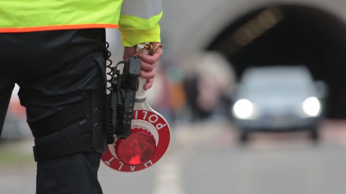 Autoposer: ARCHIV - 18.04.2025, Sachsen-Anhalt, Oberharz am Brocken: Ein Polizist steht an einer Polizeisperre. (zu dpa: «Rund 150 Fahrzeuge bei Treffen von Poser-Szene kontrolliert») Foto: Matthias Bein/dpa +++ dpa-Bildfunk +++